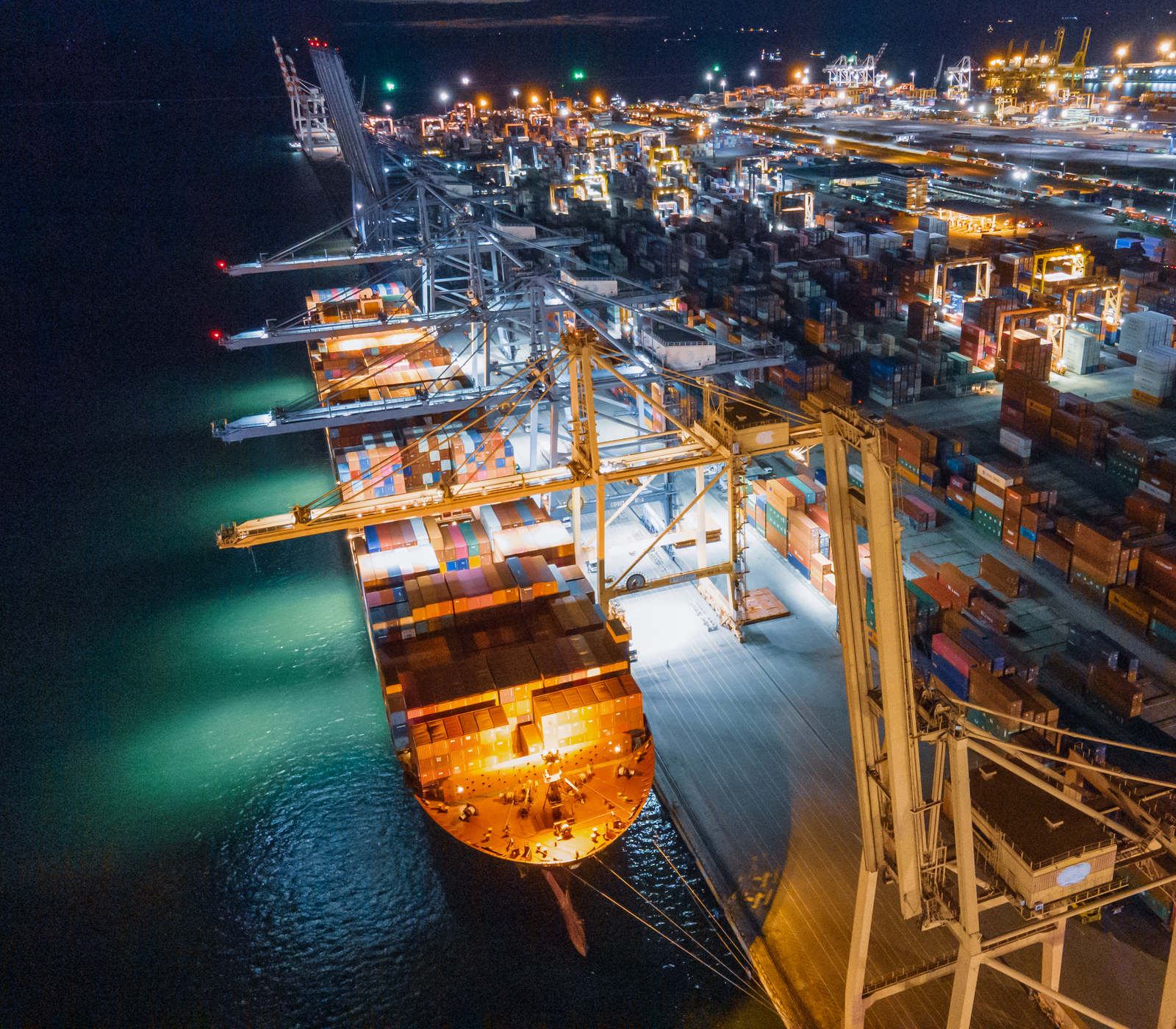 A large ship at port at night with lots of lights